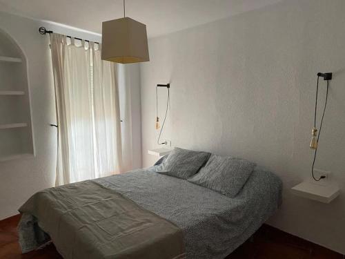 um quarto com uma cama com 2 candeeiros na parede em Casa del Aceite de Oliva Virgen Extra em Jaén