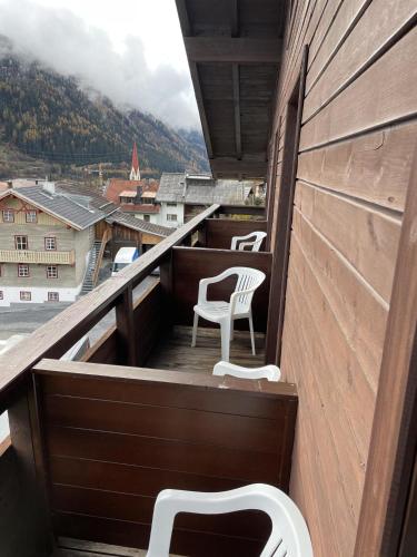 a balcony with chairs and a view of a city at Arlbergsun in Pettneu am Arlberg