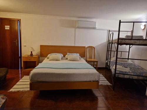 a bedroom with a bed and two bunk beds at Casa Dos Santos Alojamento - Guest House in Geres