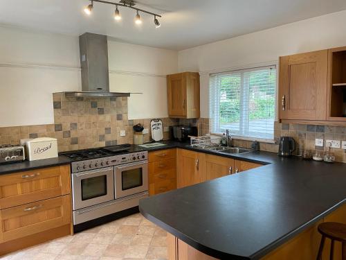 a kitchen with wooden cabinets and a stove top oven at Green Bank in Hereford