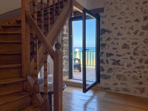 a staircase with a glass door leading to a balcony at Hotel Arimune in Bakio