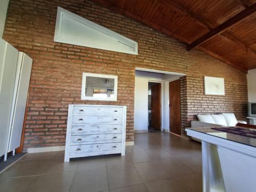 um quarto com uma parede de tijolos e uma cómoda em Luz de Luna Ubicación privilegiada frente a laguna y piscina em San Cosme