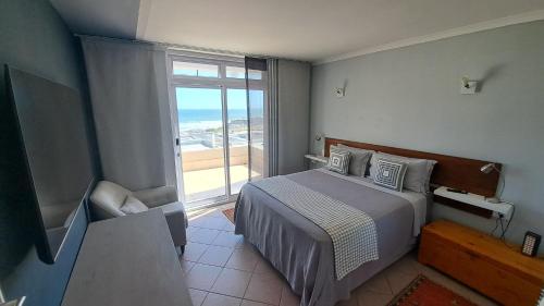 a bedroom with a bed and a large window at 2WhiteWaters Bloubergstrand Homestay in Bloubergstrand