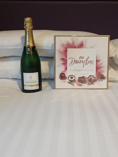 a bottle of champagne next to a box of chocolates at Ravelston House in Musselburgh