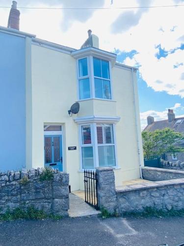 a white house with a window and a fence at Blackford House a large home Portland Dorset in Portland