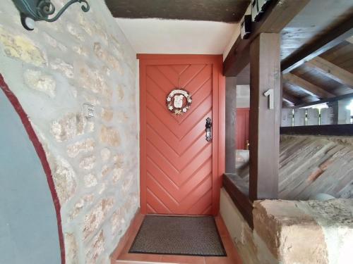 a red door in a room with a stone wall at Die alte Kantorei - historische Ferienwohnung in Kahla