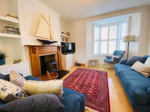 a living room with a blue couch and a fireplace at Blackford House a large home Portland Dorset in Portland