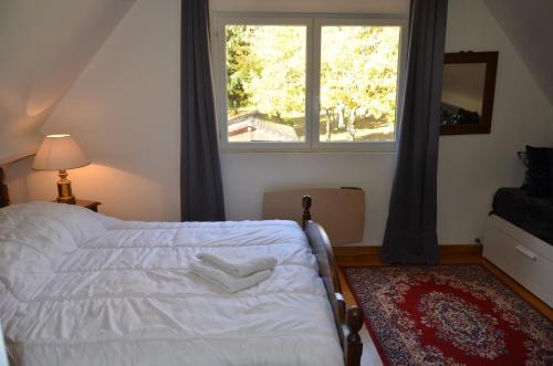 1 dormitorio con cama blanca y ventana en l'étincelle 14 pers, piscine privée chauffée, jacuzzi, sauna, calme en Saint-Martin-des-Champs