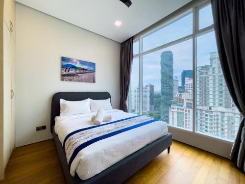 ein Schlafzimmer mit einem Bett und einem großen Fenster in der Unterkunft Soho Suites klcc by Leava in Kuala Lumpur