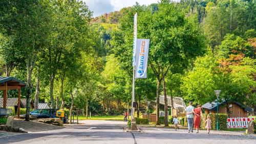 una señal para un parque con gente caminando por una calle en EuroParcs Kohnenhof, en Obereisenbach