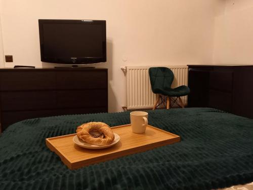 a tray with a donut on a table on a bed at First Station 26-11 in Krakow
