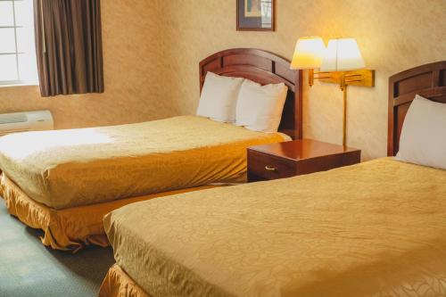 a hotel room with two beds and two lamps at Colfax Inn By Marifah in Colfax