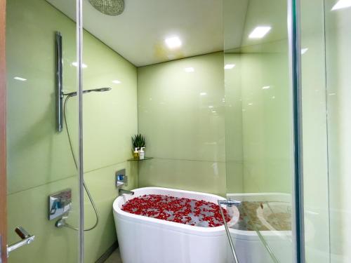 eine Badewanne mit roten Blumen im Bad in der Unterkunft Soho Suites klcc by Leava in Kuala Lumpur