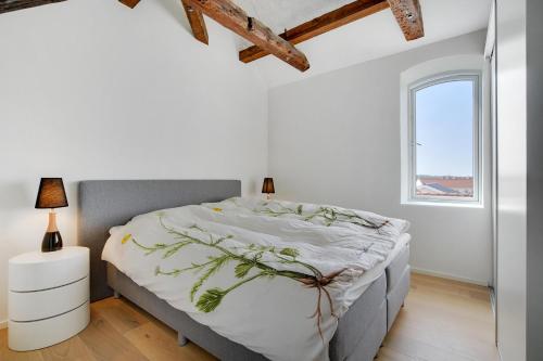 a white bedroom with a large bed and a window at Completely Renovated Holiday Apartments in Løkken