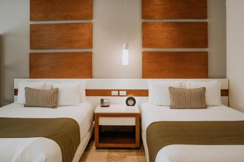 a hotel room with two beds and a table at The Reef 28 Hotel & Spa - Luxury Adults Only - All Suites - With Optional All Inclusive in Playa del Carmen