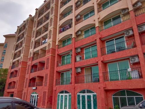 - un bâtiment rouge avec des fenêtres et des balcons dans l'établissement Seven Seas Condo Resort Beautiful Location, à Jomtien Beach