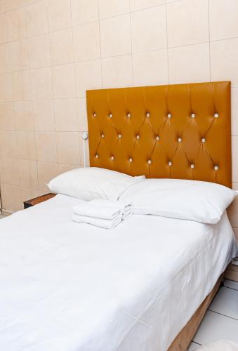 a bed with a orange headboard in a room at Nkosazana Guest House in Durban