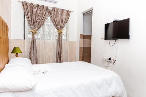 a bedroom with two beds and a flat screen tv at Nkosazana Guest House in Durban