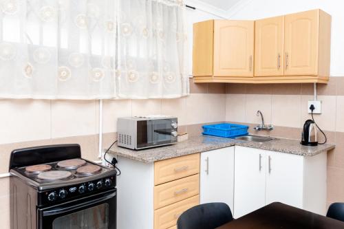 a small kitchen with a stove and a microwave at Nkosazana Guest House in Durban