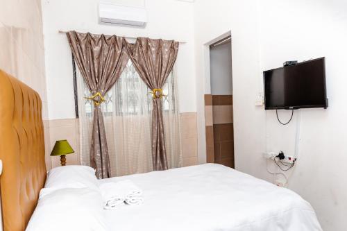 a bedroom with two beds and a flat screen tv at Nkosazana Guest House in Durban