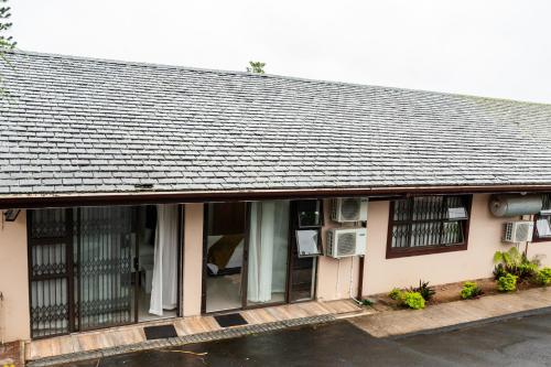 a building with a gray roof and windows at Nkosazana Guest House in Durban