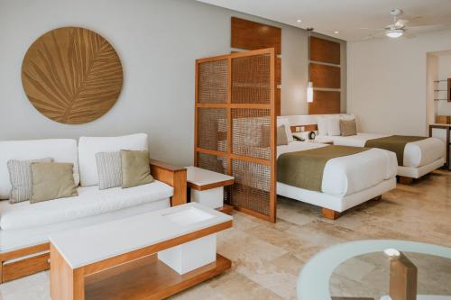 a hotel room with a bed and a couch at The Reef 28 Hotel & Spa - Luxury Adults Only - All Suites - With Optional All Inclusive in Playa del Carmen