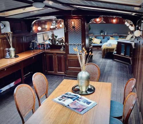 Una habitación con una mesa y sillas y un dormitorio. en AMAZING PRIVATE LUXURY BOAT ACCOMMODATION, en Ámsterdam