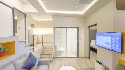 a living room with a couch and a tv at Hotel Z zpaze in Bangkok