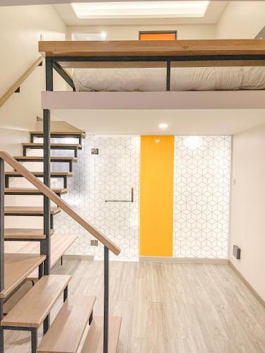 a loft bedroom with stairs and a yellow wall at Hotel Z zpaze in Bangkok