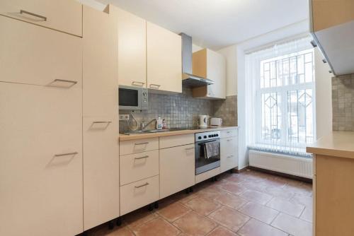 ウィーンにあるSpacious central apartmentの白いキャビネットと窓付きのキッチン