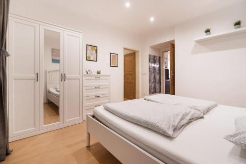 ウィーンにあるSpacious central apartmentの白いベッドルーム(ベッド1台、バスルーム付)