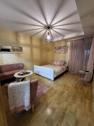 sypialnia z łóżkiem, kanapą i stołem w obiekcie Apartman Golden Rose w mieście Loznica