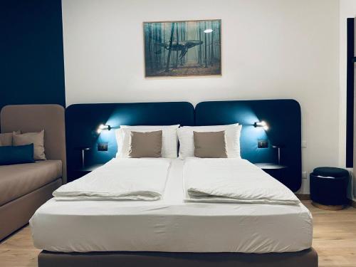 a bedroom with a large bed with a blue headboard at House of Bruno - Only self check-in in Trento