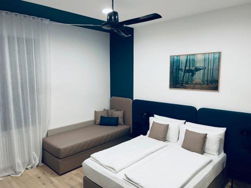 a room with two beds and a couch and a ceiling fan at House of Bruno - NO Reception in Trento
