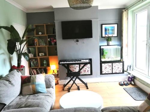 ein Wohnzimmer mit Couch und Flachbildfernseher in der Unterkunft En-Suite Double Room (compact) in Strood, Rochester in Rochester