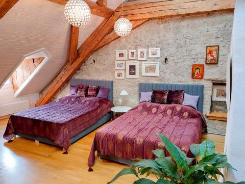2 camas en un dormitorio ático con techos de madera en Maison D'Ammann, en Fribourg
