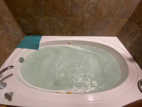 a white bath tub filled with water in a bathroom at The Getaway 