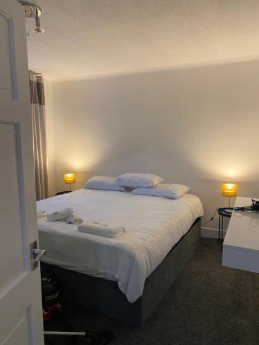 a bedroom with a bed with white sheets and pillows at M&J Apartment in Blackpool