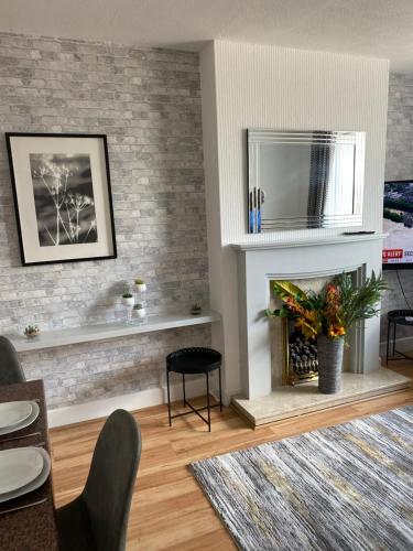 a living room with a brick wall with a fireplace at M&J Apartment in Blackpool