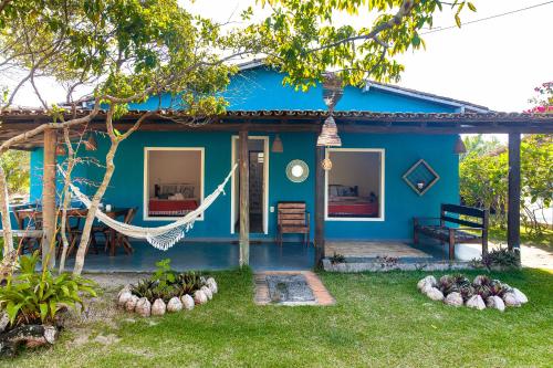 uma casa azul com uma rede em frente em Pousada Vila Rosa - Caraiva em Caraíva