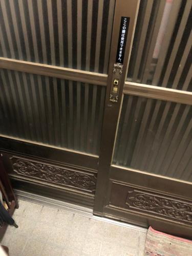 a black door with a metal gate in a room at 桃源郷２ in Toba