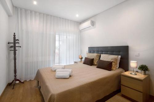 una camera da letto con un letto grande e una finestra di Apartamento Peron a Quarteira