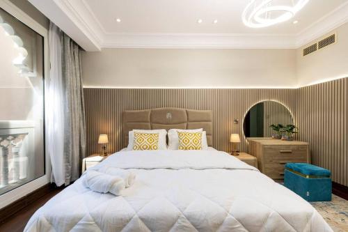 1 dormitorio con 1 cama blanca grande y espejo en Luxury 1Bedroom on Private Beach Residence at Palm, en Dubái