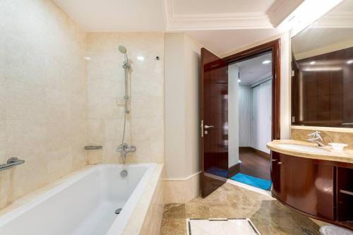 bagno con vasca, doccia e lavandino di Luxury 1Bedroom on Private Beach Residence at Palm a Dubai