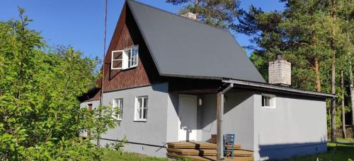 a small white house with a brown roof at Türi Holiday Home, a simple house in Türi