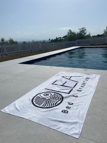 a swimming pool with a sign on the ground next to it at Olea b&b in Montecosaro