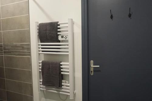 La salle de bains est pourvue d'un porte-serviettes à côté d'un miroir. dans l'établissement Cosy T2 Wifi Parking Proche gare CENTRE VILLE, à Saint-Quentin