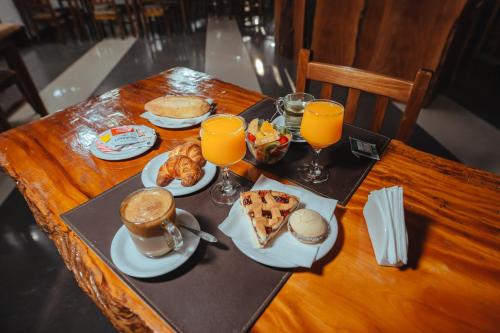 a table with breakfast foods and orange juice on it at Palo Rosa Lodge in Puerto Iguazú