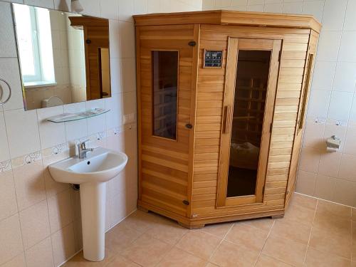 baño con lavabo y armario de madera en Aquarius, en Podgortsy