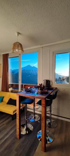 - un salon avec une table, des chaises et des fenêtres dans l'établissement Orcières Rond Point des Pistes 1 Panoramique, Front de Neige, à Orcières